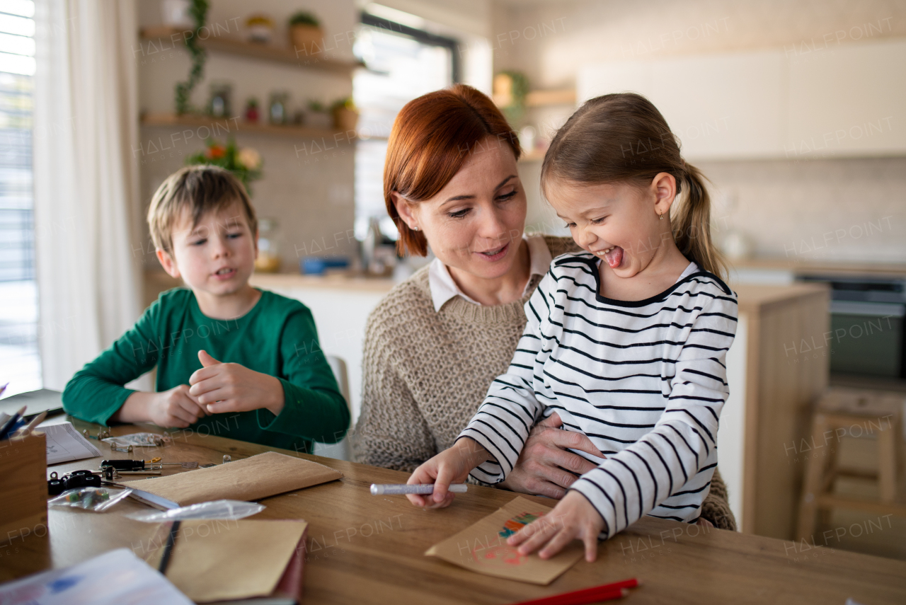 A mother of little children supervising them when diong homework at home.