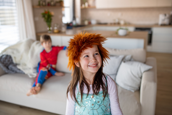 Happy little children in costumes playing at home.