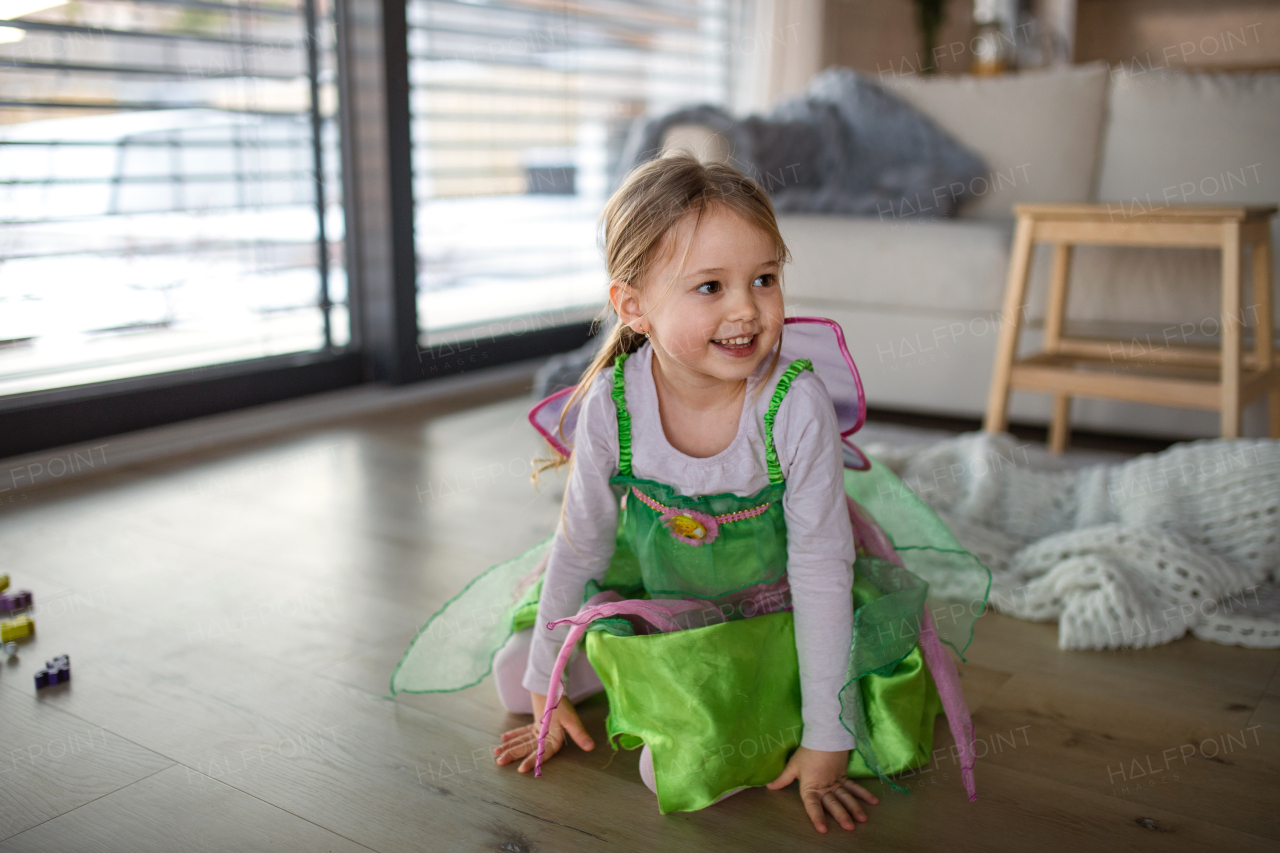 A little girl in fairy costume playing at home.