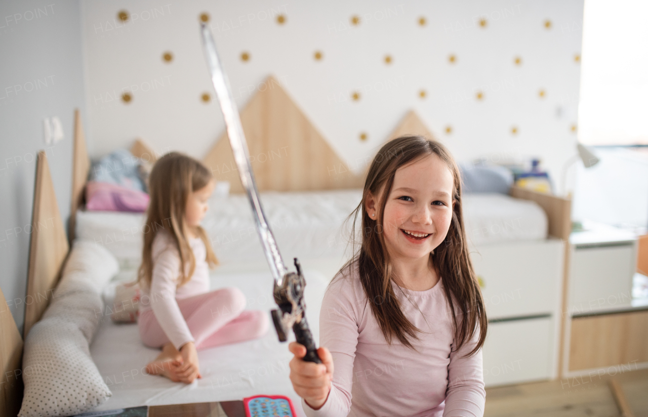 Cheerful little sisters in playing at home.