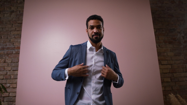 A happy young businessman looking at camera, studio shooting concept.