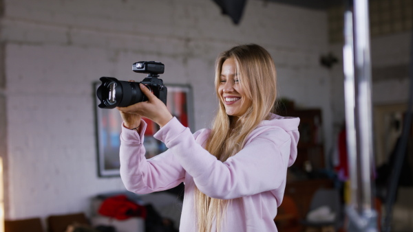 A young photographer taking picures of model, backstage of photoshooting in studio.