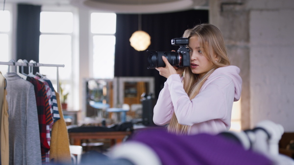 A young photographer taking picures of model, backstage of photoshooting in studio.