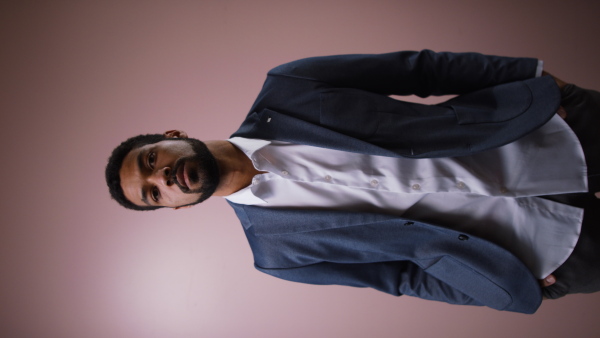 A serious young businessman looking at camera, studio shot.