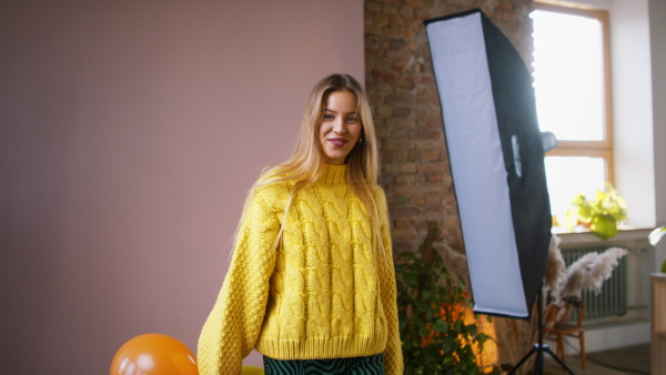 A fashion studio shooting of a happy young woman with balloons , backstage of photoshooting .