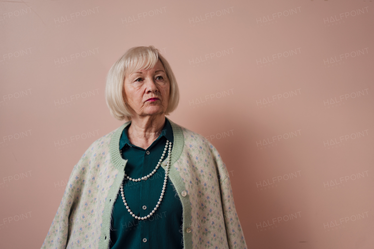 A senior woman sitting on sofa and reading book at home