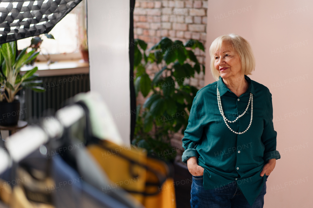 A smiling elderly woman posing at stylish showroom.