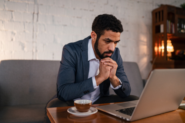 A busy young businessman having coffee and doing his work.