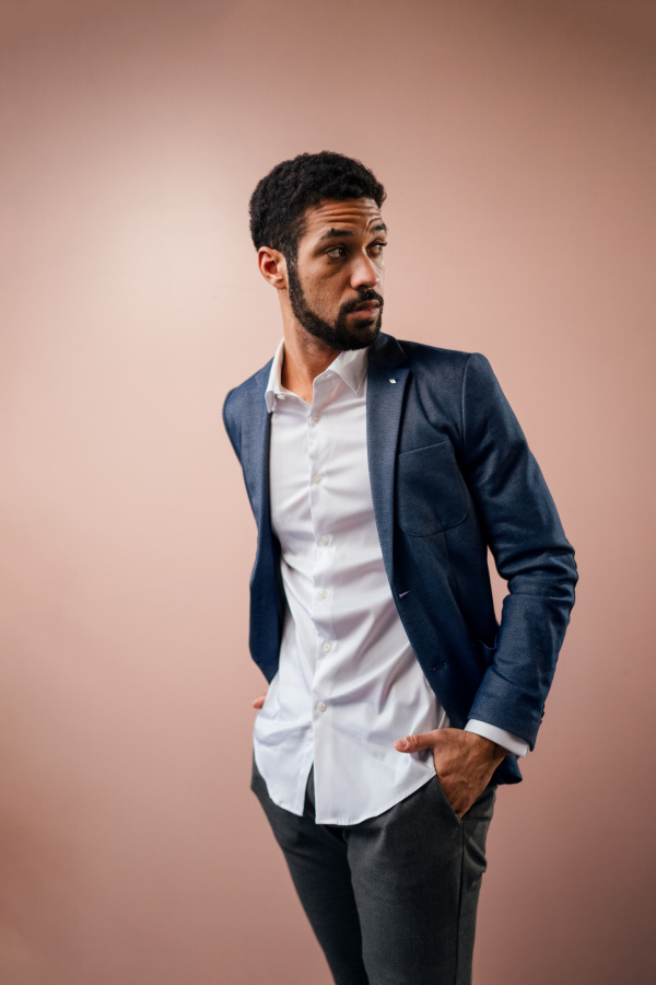 A serious young businessman looking away, studio shot.