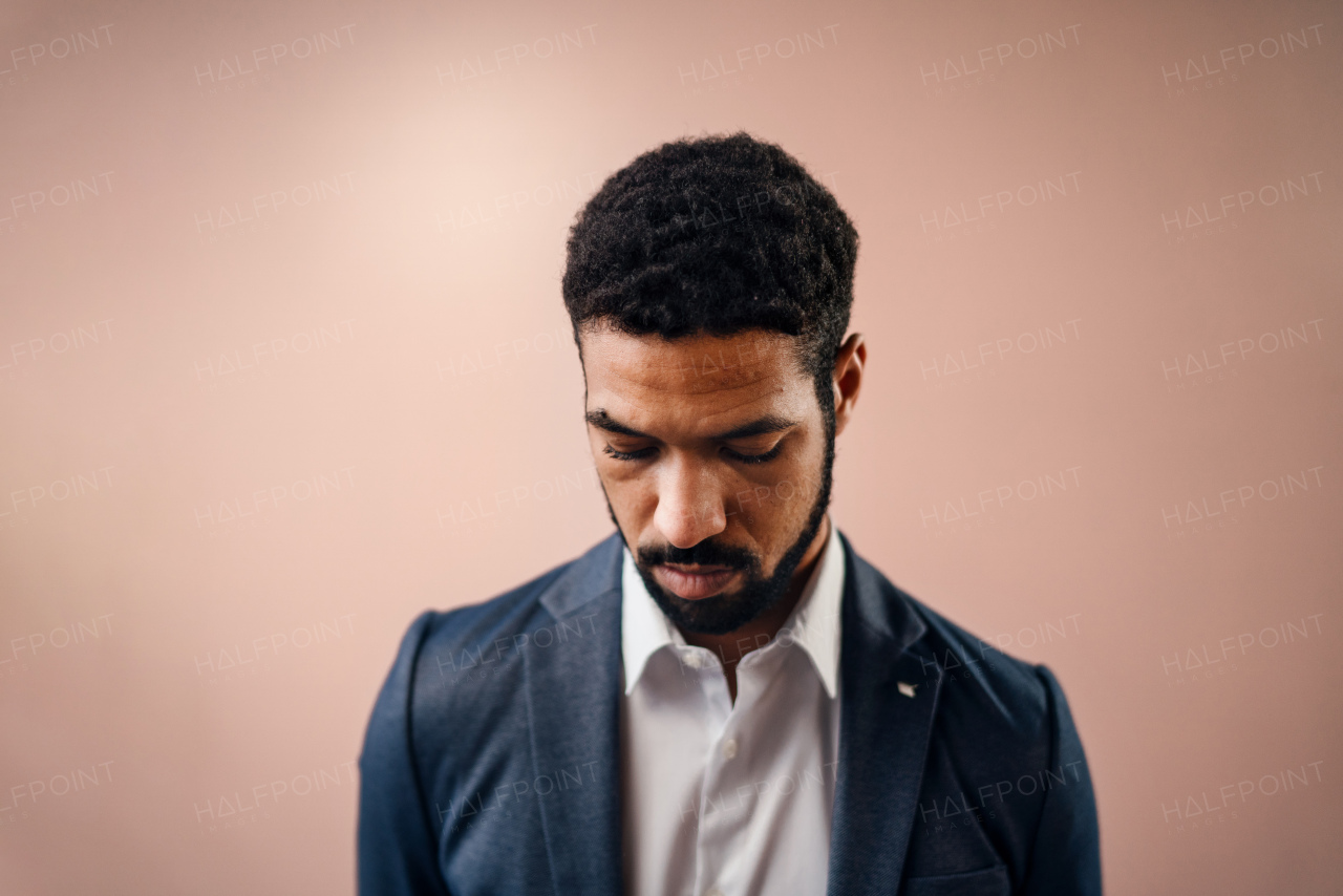 A serious young businessman looking away, studio shot.