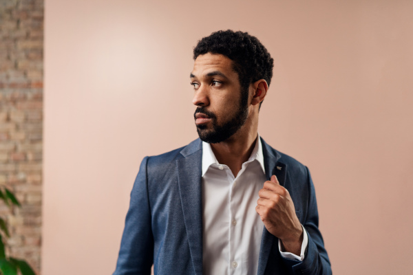 A serious young businessman looking away, studio shot.