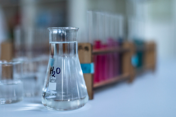 Close up of measuring cups and testing tube in a chemist laboratory.