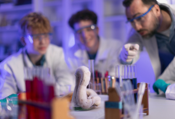 Science students with a teacher doing chemical reaction experiment in the laboratory at university.