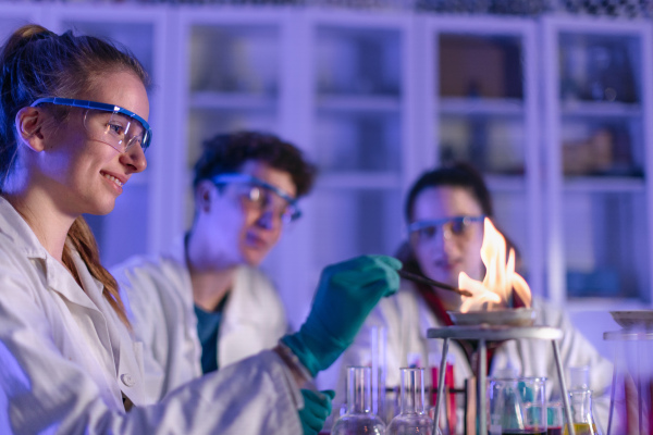 Science students doing a chemical experiment in the laboratory at university. Close-up.