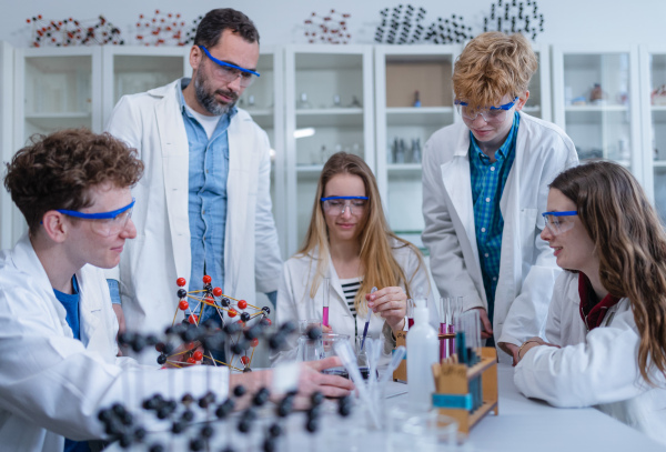 Science students with a teacher doing chemical reaction experiment in the laboratory at university. Low angle view.