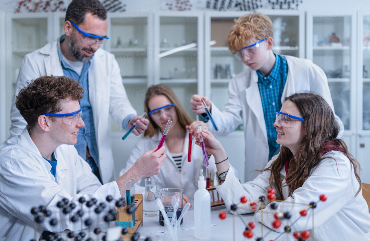 Science students with a teacher doing chemical reaction experiment in the laboratory at university. Low angle view.