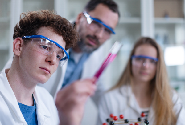 Science students doing a chemical experiment in the laboratory at university.