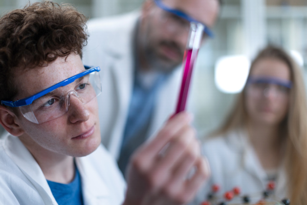 Science students doing a chemical experiment in the laboratory at university.