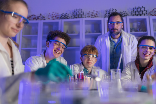 Science students with a teacher doing chemical reaction experiment in the laboratory at university.