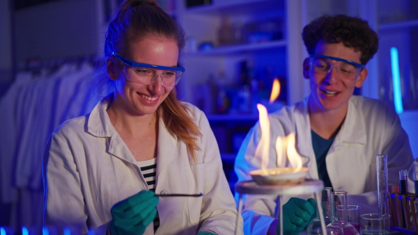 Excited science students doing a chemical experiment in the laboratory at university.