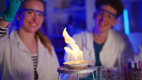 Excited science students doing a chemical experiment in the laboratory at university.