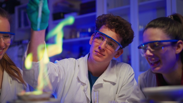 Excited science students doing a chemical experiment in the laboratory at university.