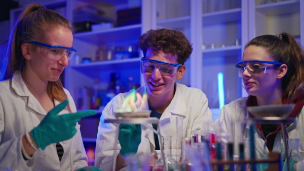 Excited science students doing a chemical experiment in the laboratory at university.