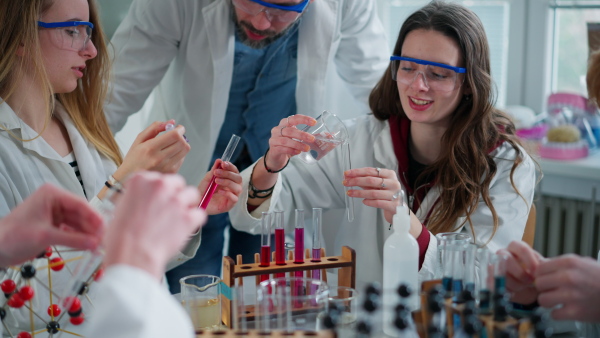 Science students doing a chemical experiment in the laboratory at university.