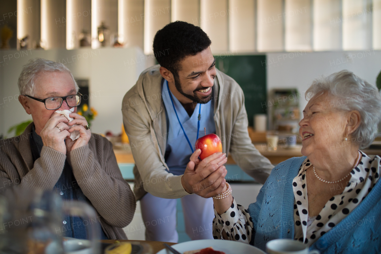 A smiling elderly woman and man enjoying breakfast in nursing home care center.