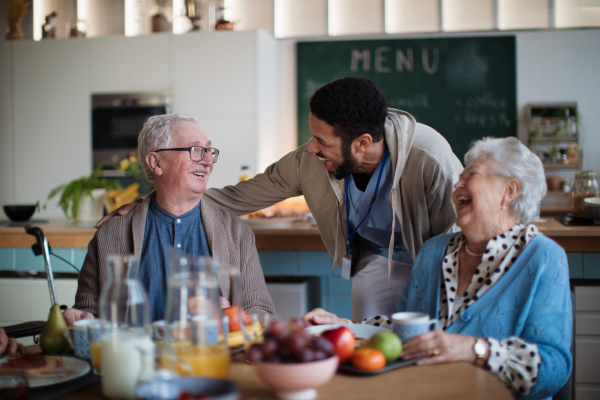 A group of cheerful seniors enjoying breakfast in nursing home care center.