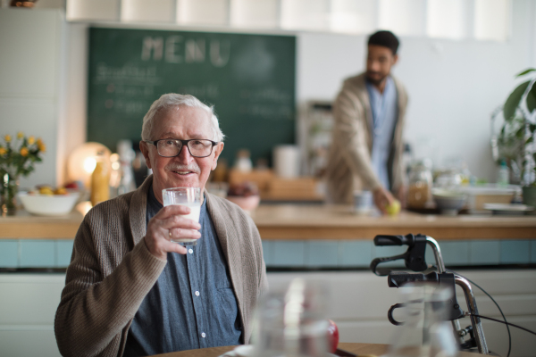 A smiling elderly man enjoying breakfast in nursing home care center.