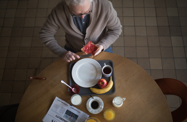 Top view of senior man having a breakfast in nursing home care center.