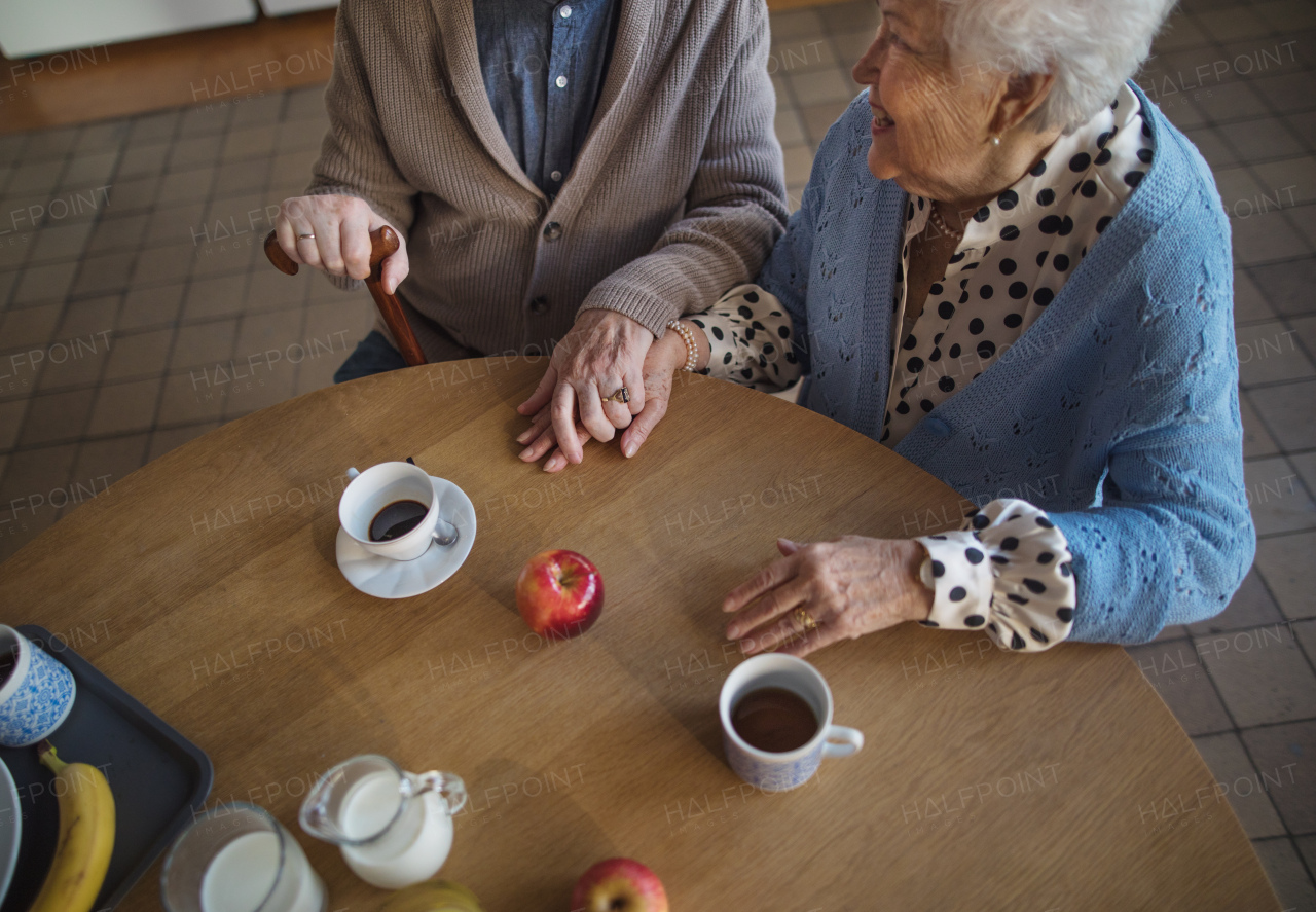 A top view of elderly couple enjoying breakfast in nursing home care center.