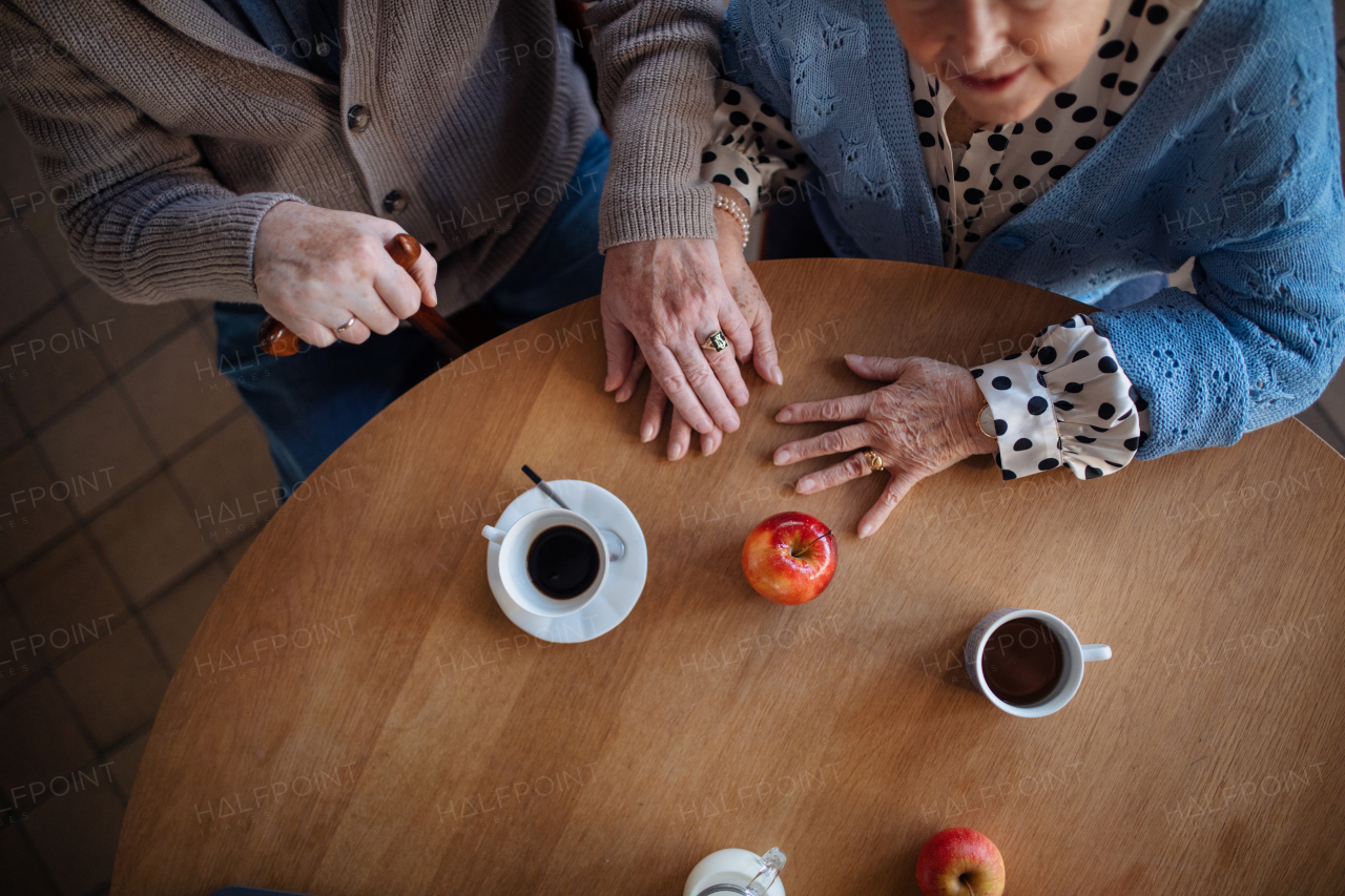 A top view of elderly couple enjoying breakfast in nursing home care center.