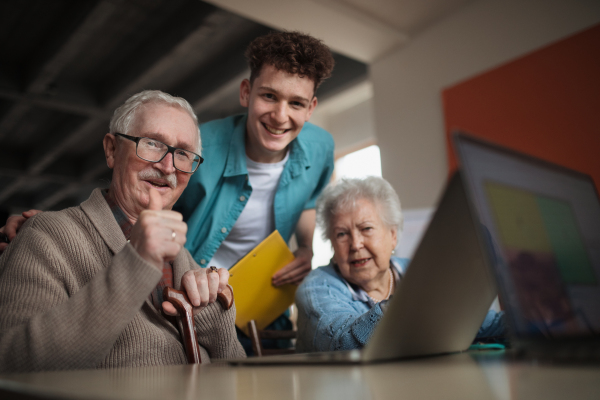 A senior group in retirement home with young instructor learning together in computer class