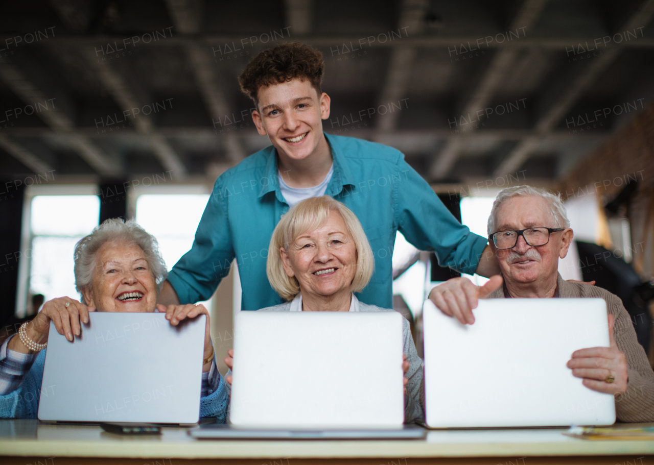 A senior group in retirement home with young instructor learning together in computer class