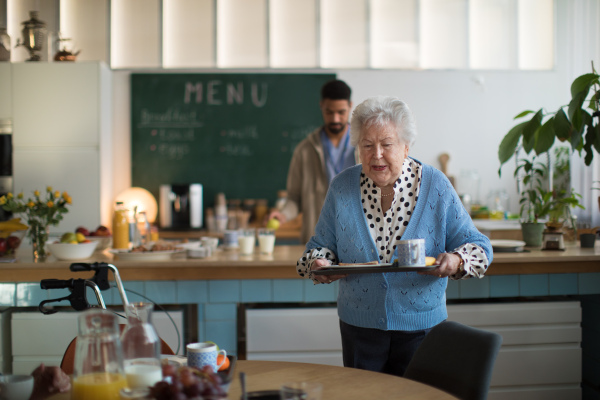 Smiling elderly women enjoying breakfast in a nursing home care center.