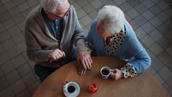 A top view of elderly couple enjoying breakfast in nursing home care center.