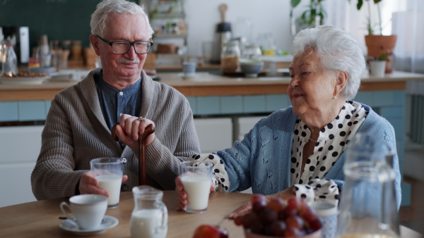 A senior couple enjoying breakfast in nursing home care center.