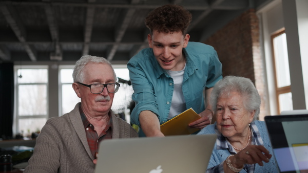 A senior group in retirement home with young instructor learning together in computer class