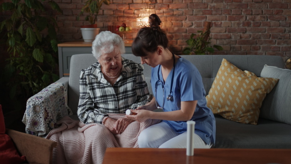 Medical nurse consulting medication with elderly woman at retirement home