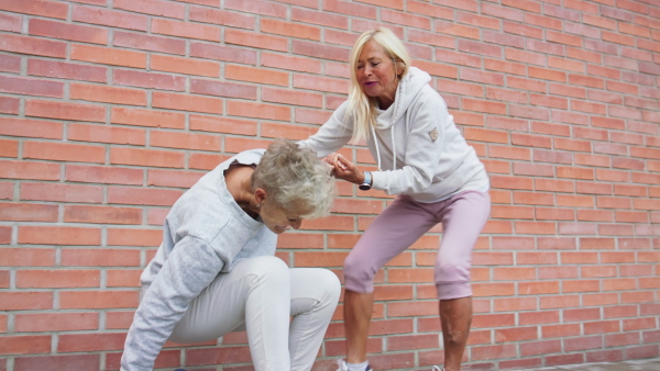 A cheerful group of senior women having fun after exercise outdoors in street