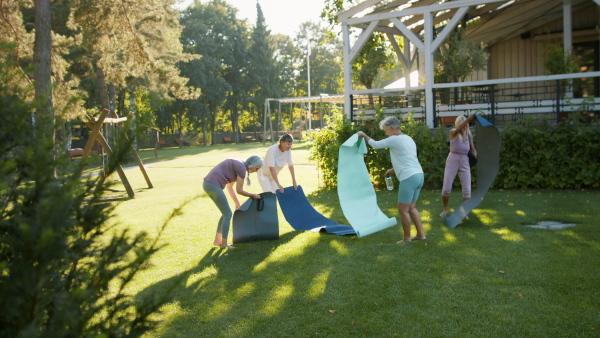 Senior women friends getting ready for exercise outdoors in a park.