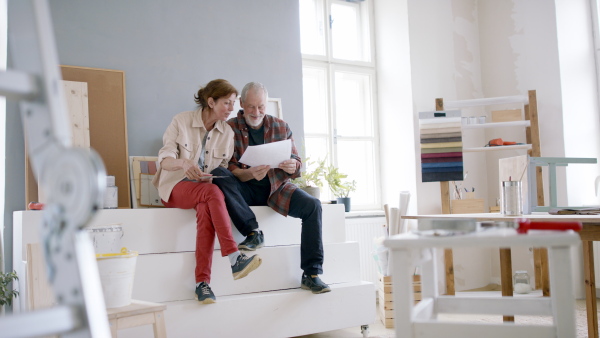 Beautiful senior couple planning the renovation of their new flat.