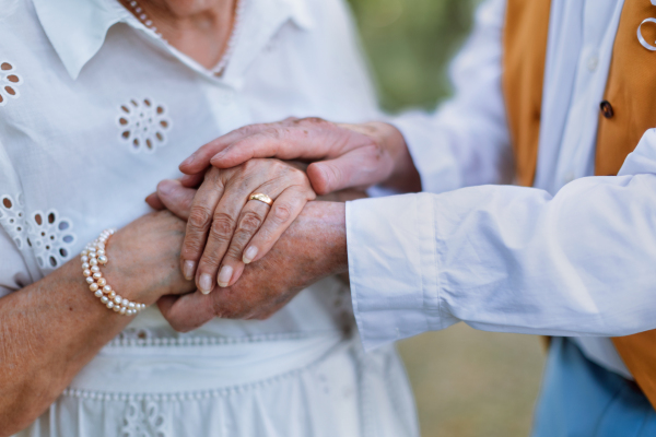 Close-up of seniors hands with golden wedding rings during their marriage.