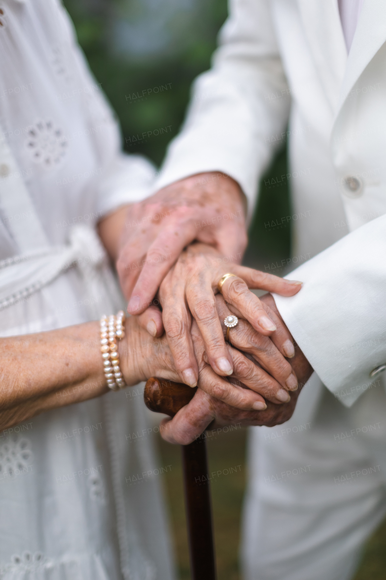 Close-up of seniors hands with golden wedding rings during their marriage.