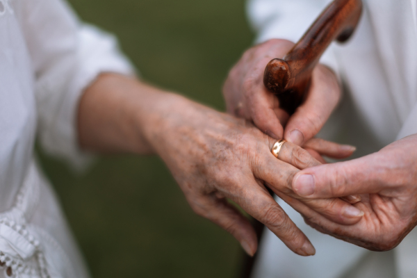 Close-up of seniors hands with golden wedding rings during their marriage.