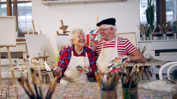 Senior couple painting together in an artist atelier.