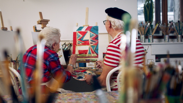 Senior couple painting together in an artist atelier.