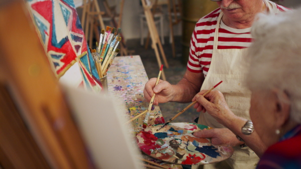 Senior couple painting together in an artist atelier.